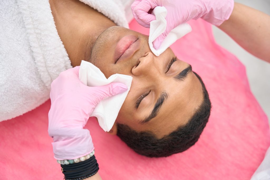 Beauty clinic dermatologist preparing patient for aesthetic procedure
